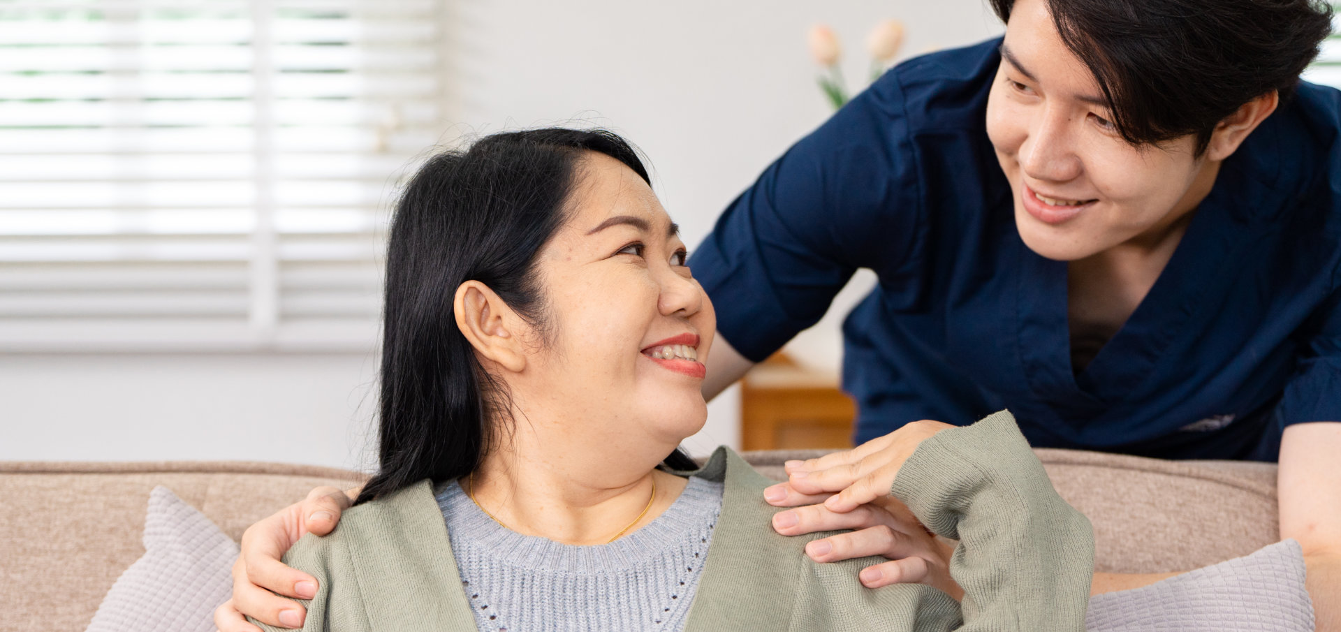 A man and woman smiling at each other on a couch
