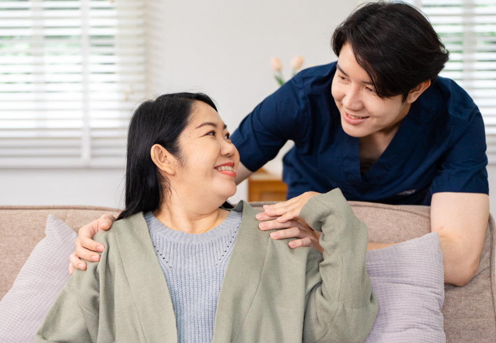 A man and woman smiling at each other on a couch