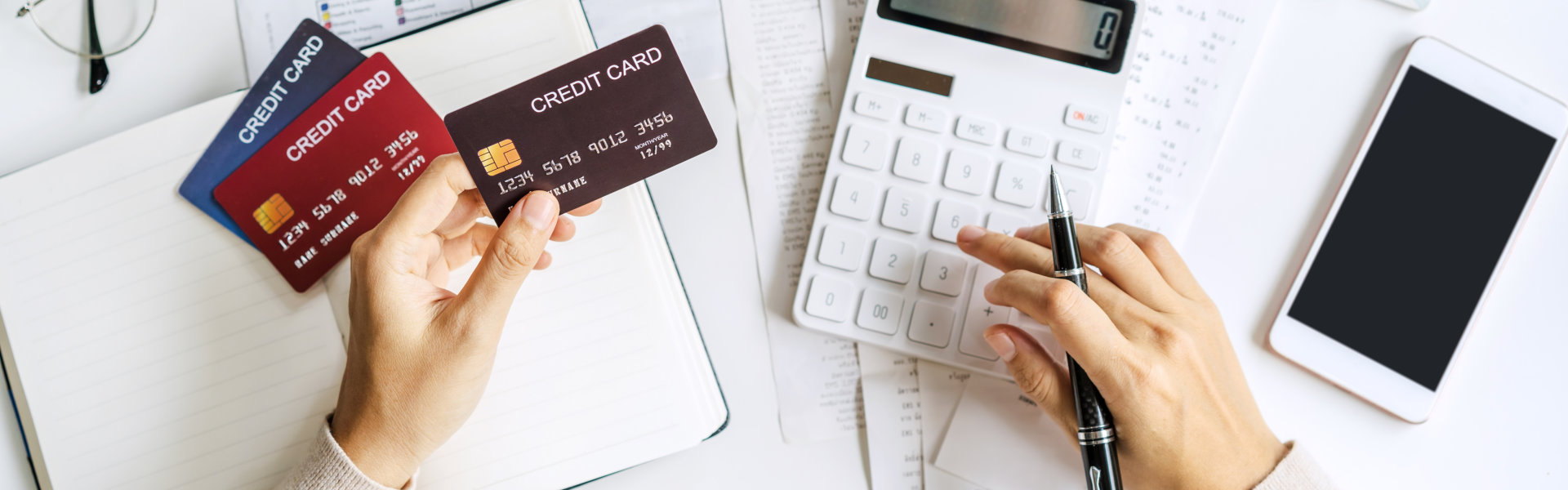 a person's hands holding two credit cards